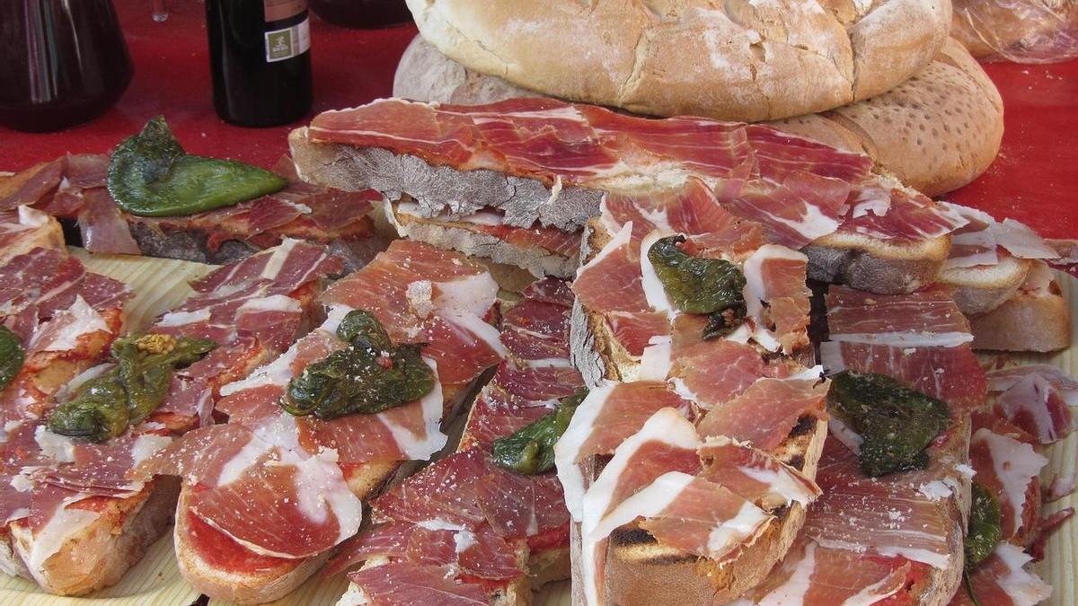 Unas tostadas con tomate, jamón y pimiento.