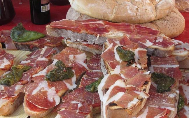 Unas tostadas con tomate, jamón y pimiento.