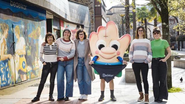 Representantes de Bedelkar con la mascota 'Bedelkartxo' y el nuevo logotipo.