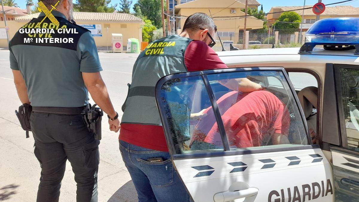 Dos agentes de la Guardia Civil custodian a un detenido.