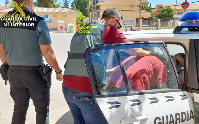 Dos agentes de la Guardia Civil custodian a un detenido.