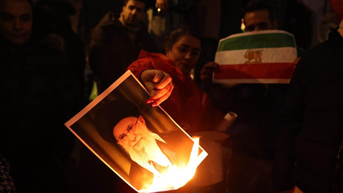 Protestantes queman un retrato de Alí Jamenei, líder supremo de Irán.
