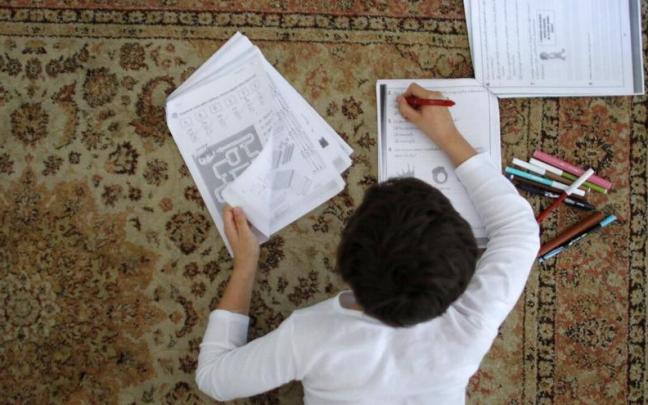 Un niño realiza ejercicios matemáticos en su casa. Un niño realiza ejercicios matemáticos en su casa.