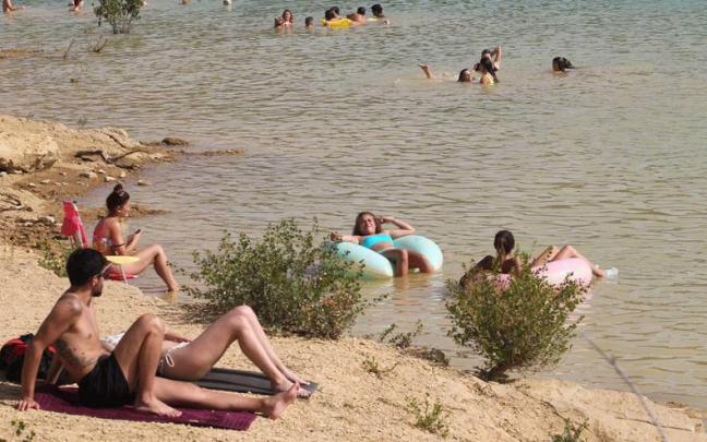 Varias personas se bañan en el pantano de Alloz.