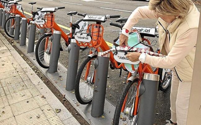 Una usuaria retira una bicicleta junto a la estación del metro de Berango