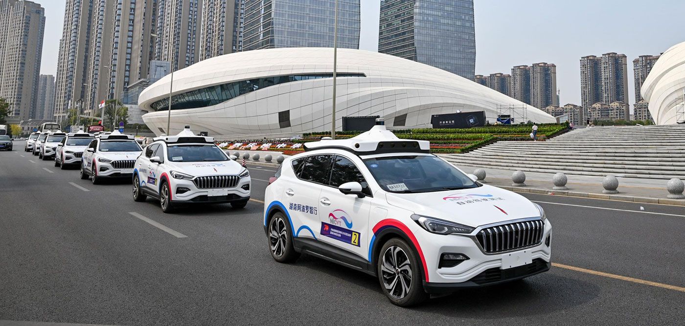 Robotaxis pasan junto al Meixihu Cultural Art Center en Changsha (China).