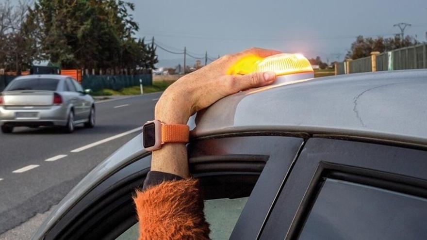Un conductor coloca una baliza para señalizar que su vehículo ha sufrido un percance.