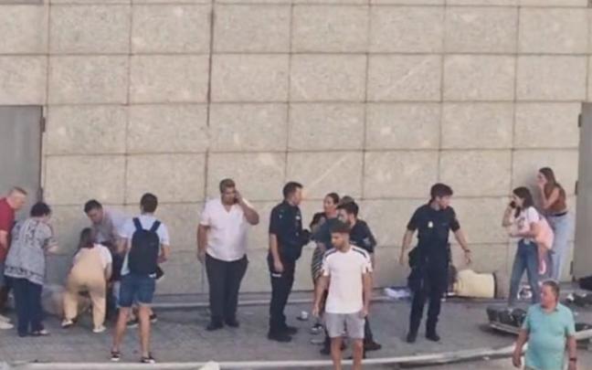 Varios viandantes y policías atienden a los heridos en la zona del atropello.