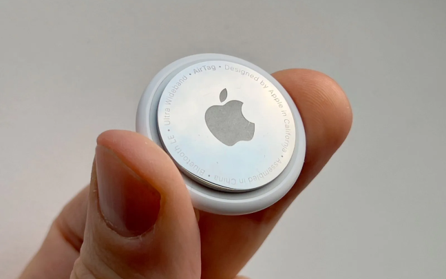 Una mano sosteniendo un AirTag