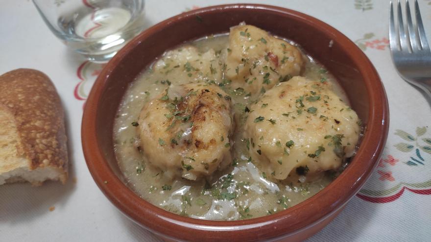 Una cazuelica con varias albóndigas de merluza en salsa verde.
