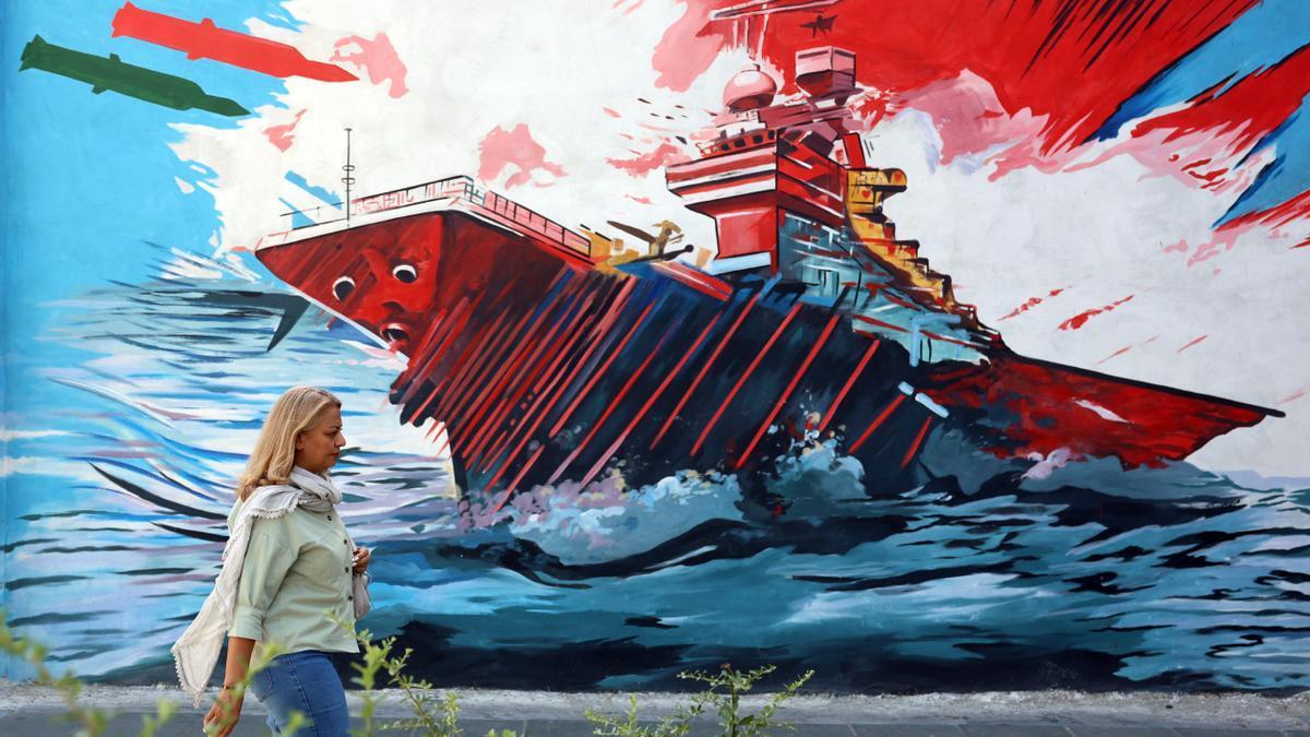 Una iraní camina junto a un mural contra EE.UU. en Teherán.
