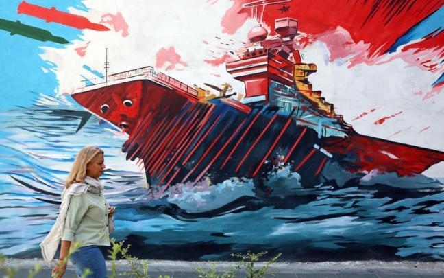 Una iraní camina junto a un mural contra EE.UU. en Teherán.