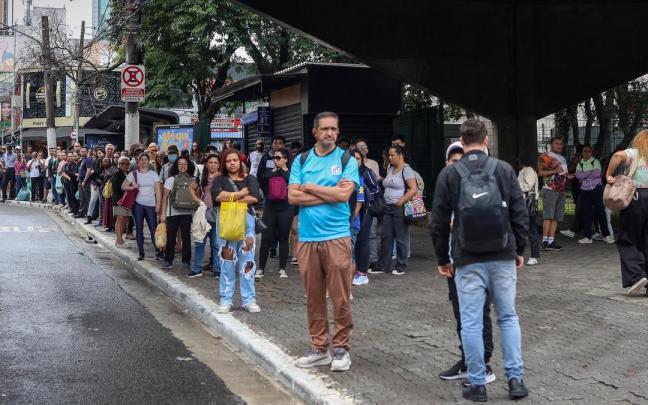 Ciudadanos brasileños esperan en una parada de autobús abarrotada este domingo, debido a la demora de los vehículos durante la segunda vuelta de las elecciones en Brasil.