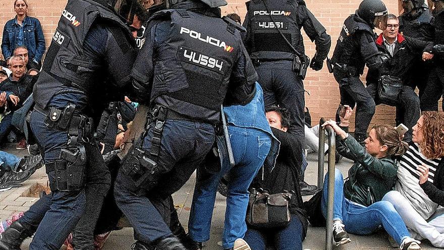 Agentes de la Policía Nacional cargan contra manifestantes independentistas en Barcelona, durante el 1 de octubre de 2017.