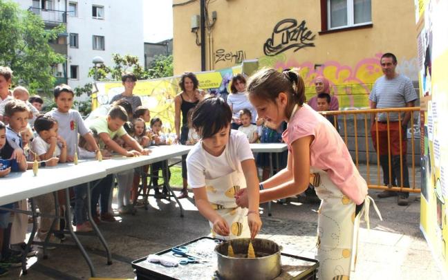 Dos niñas participando en el taller para hacer velas que dirige Erlantz Olabarria en la pasada edición de la feria.