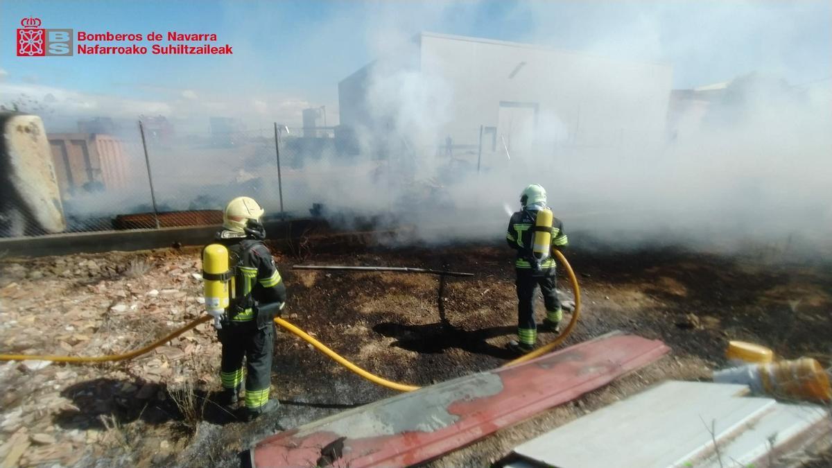 Dos bomberos trabajan en la extinción del incendio en el almacén de la bodega