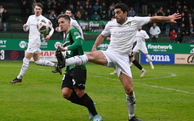 Koldo Berasaluze intenta frenar a Leandro, del Sestao, en el derbi de Las Llanas.