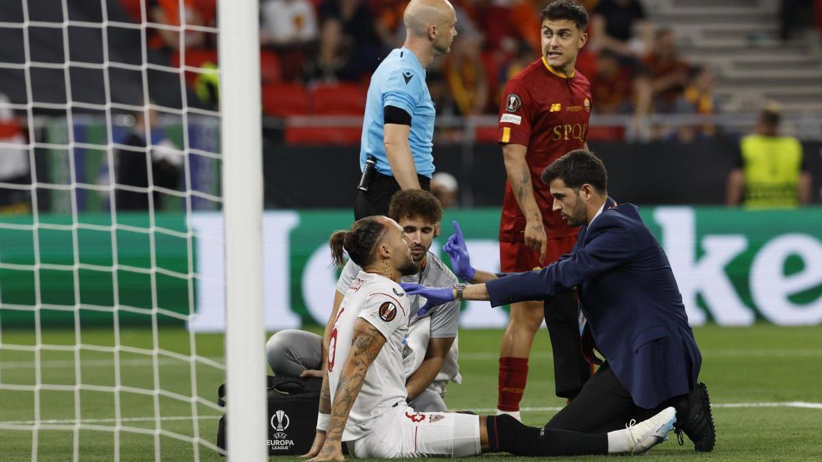 El centrocampista del Sevilla FC Nemanja Gudelj (i) recibe asistencia tras un acción.