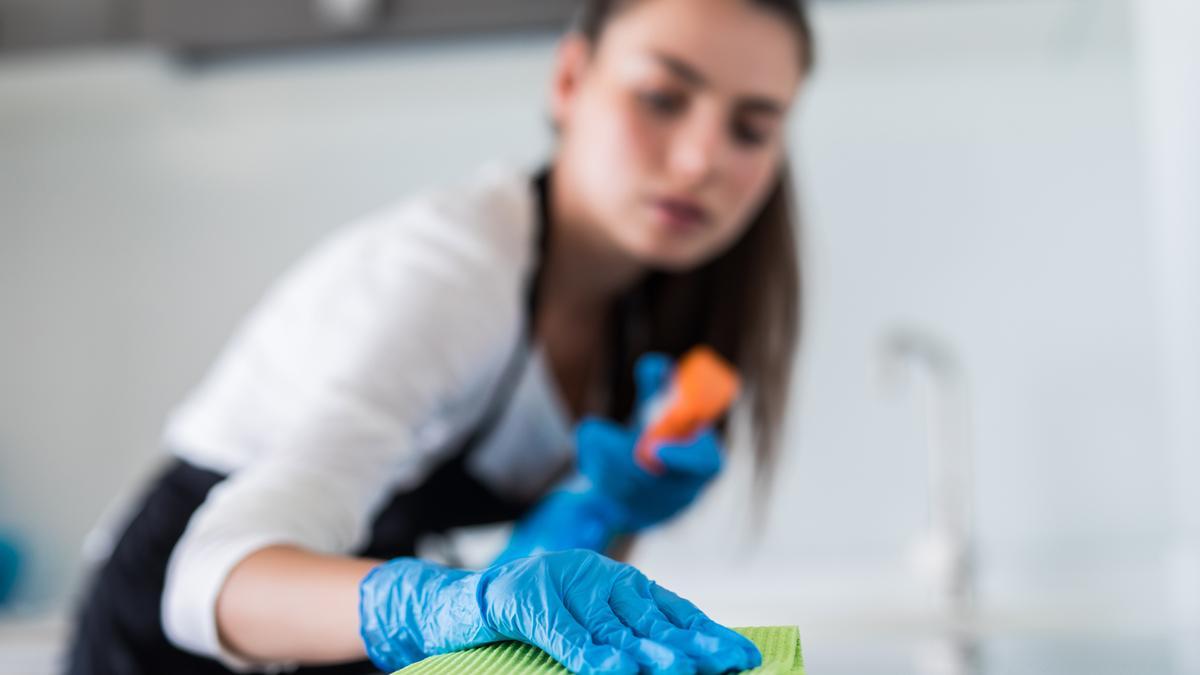 Mujer limpiando la vitrocerámica.