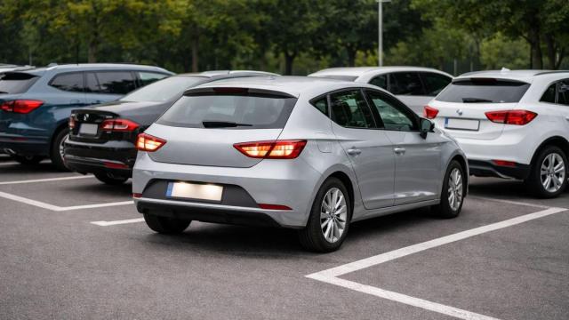 Un coche sale marcha atrás de una plaza de aparcamiento.