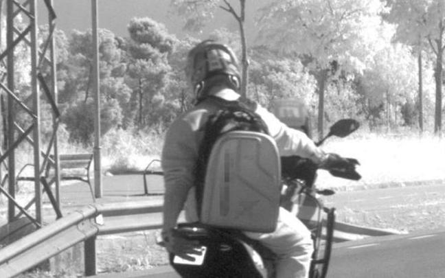 El motorista, tapando la matrícula con la mano.