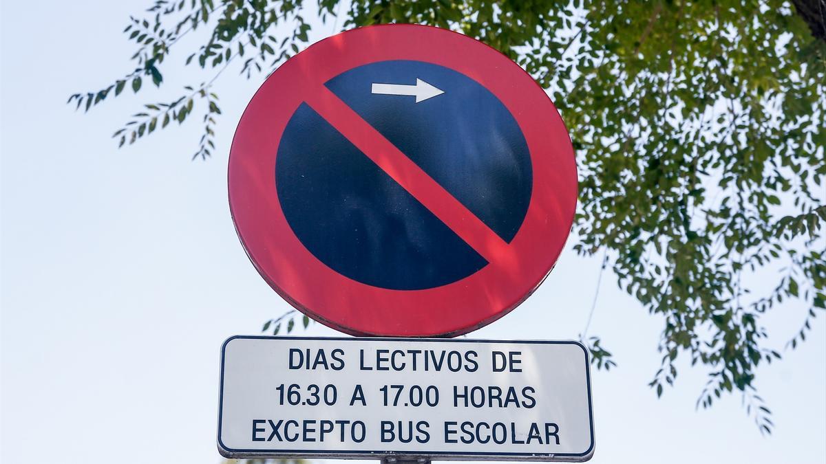 Señal de prohibido aparcar a la derecha (restricción de horas) excepto bus escolar.
