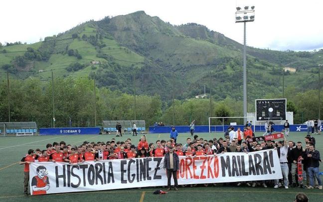 'Txus' Alzaga eta Urki CD taldeko jokalariak eta zaletuek igoera ospatzen Unbeko futbol zelaian.