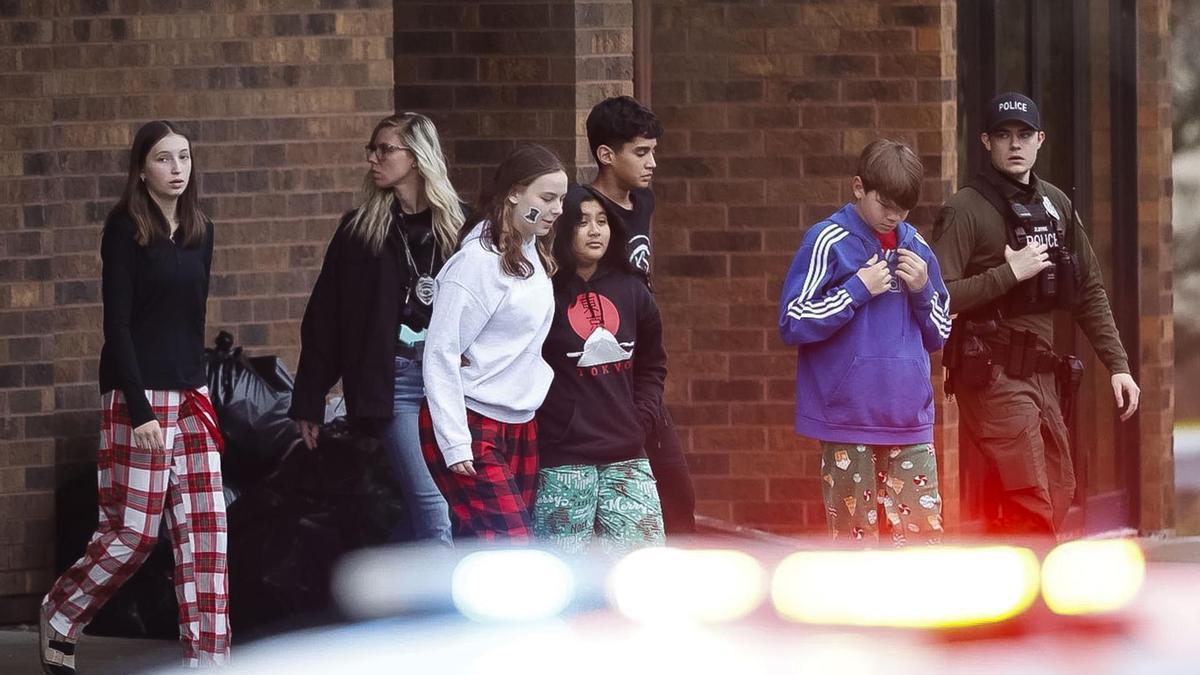 Un grupo de menores es escoltado fuera del colegio tras el tiroteo.