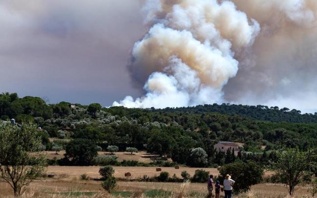 Varias personas observan el humo del incendio, en La Bisbal d'Empordà, Girona.