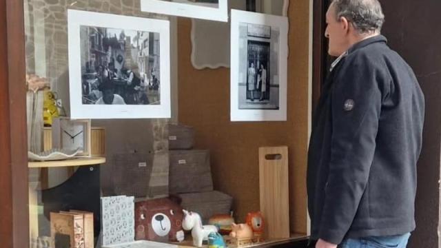 Un hombre contempla las fotos antiguas colocadas en un escaparate comercial en Amurrio