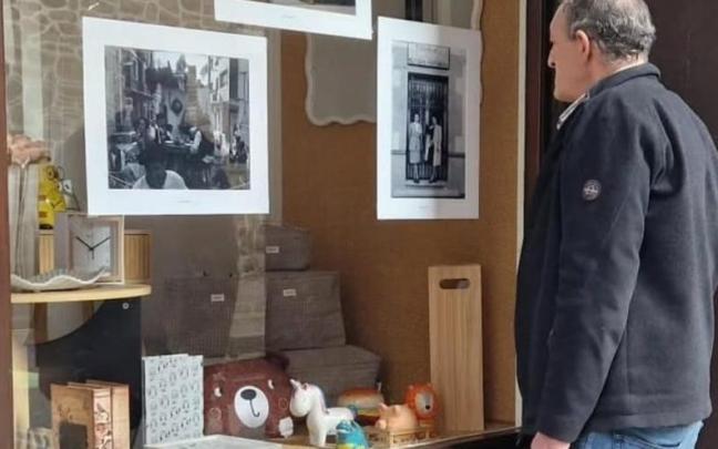 Un hombre contempla las fotos antiguas colocadas en un escaparate comercial en Amurrio