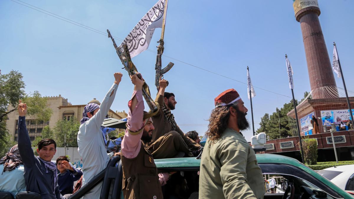 Afganos simpatizantes del régimen celebran en las calles, armados con fusiles, los tres años de los talibán en el poder.