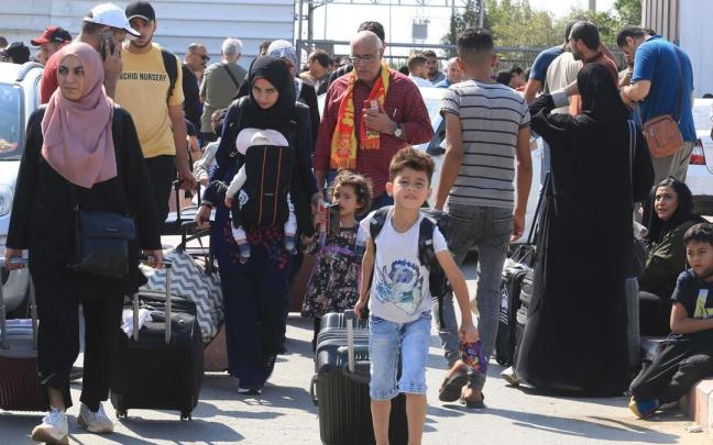 Palestinos esperan para acceder a Egipto por el paso de Rafah.