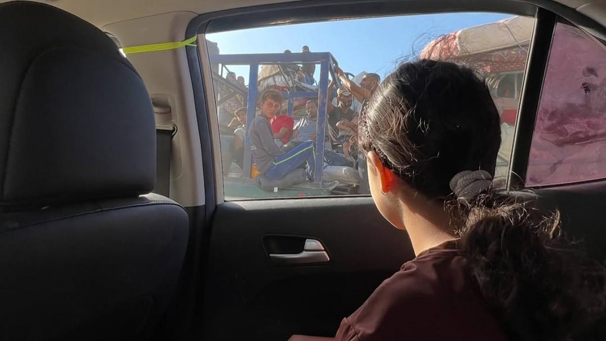 La niña gazatí Jenaan Nabil, de solo 10 años, mira desde el cristal del coche mientras se desplaza junto a su familia debido a la guerra.