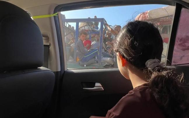 La niña gazatí Jenaan Nabil, de solo 10 años, mira desde el cristal del coche mientras se desplaza junto a su familia debido a la guerra.
