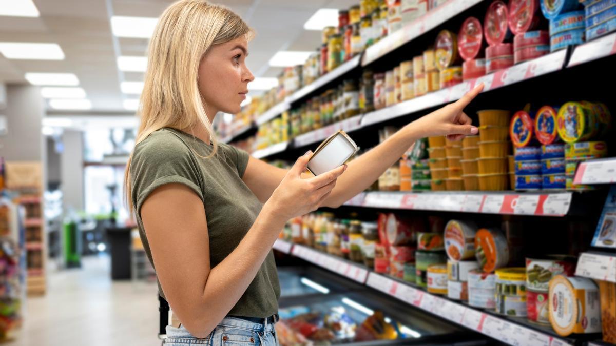 Una mujer compara precios en el súper.