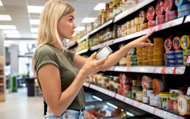 Una mujer compara precios en el súper. Una mujer compara precios en el súper.