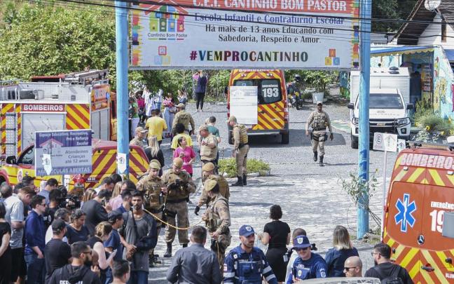 Bomberos y agentes de seguridad atienden un ataque con arma blanca hoy, en la entrada de la guardería Cantinho Bom Pastor hoy, en Blumenau (Brasil).