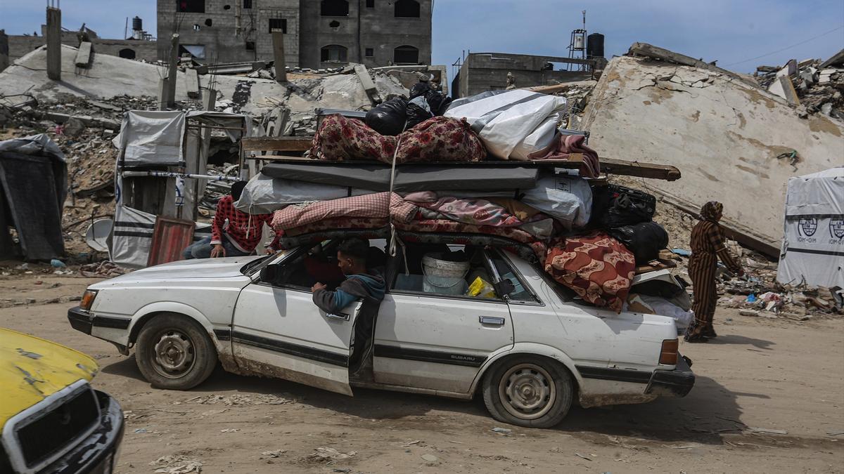 Refugiados palestinos trasladan sus pertenencias en coche en Gaza.
