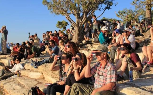 Gente utilizando visores solares portátiles y gafas para eclipse solar para ver un eclipse solar de forma segura