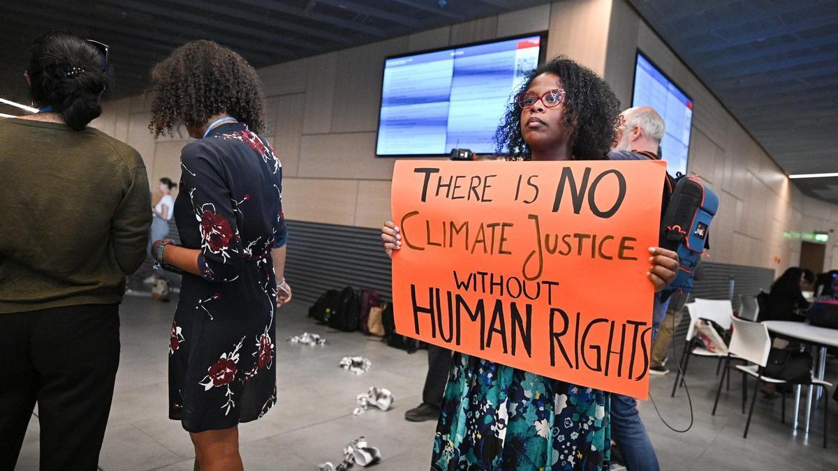 Una mujer manifestándose en el Bundestag durante la precumbre del clima de Bonn