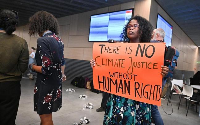 Una mujer manifestándose en el Bundestag durante la precumbre del clima de Bonn