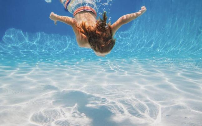 Un menor se sumerge en el agua