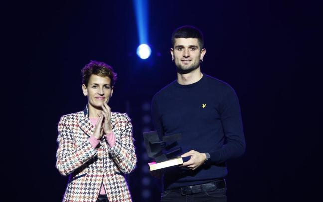 Asier Martínez recibe el premio de la mano de María Chivite.