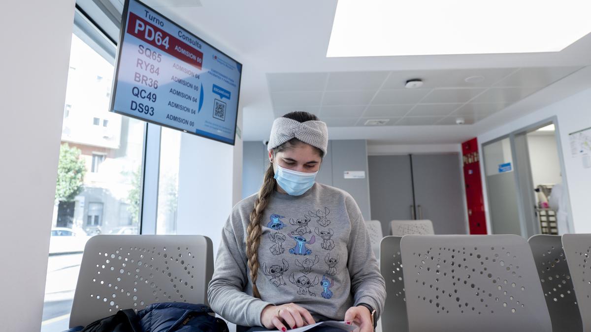 Una joven con mascarilla en un hospital.