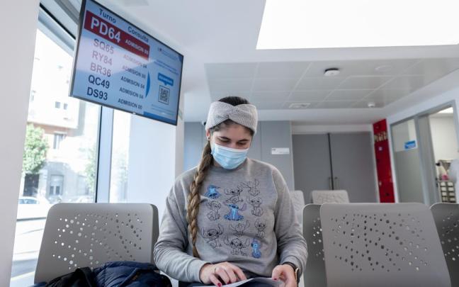 Una joven con mascarilla en un hospital.