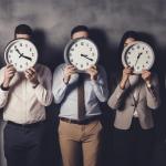 Varios trabajadores de una empresa, con relojes marcando diferentes horas.