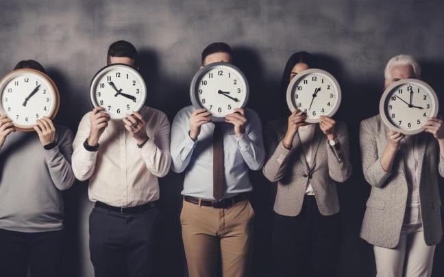 Varios trabajadores de una empresa, con relojes marcando diferentes horas.