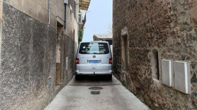 Un coche trata de pasar por la estrechísima calle.