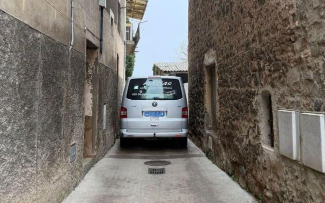 Un coche trata de pasar por la estrechísima calle.